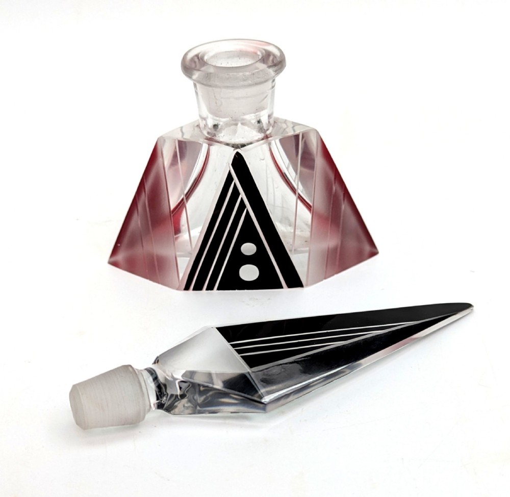 An Art Deco clear and frosted glass perfume bottle featuring a tall faceted stopper and black enamelled geometric designs. View V