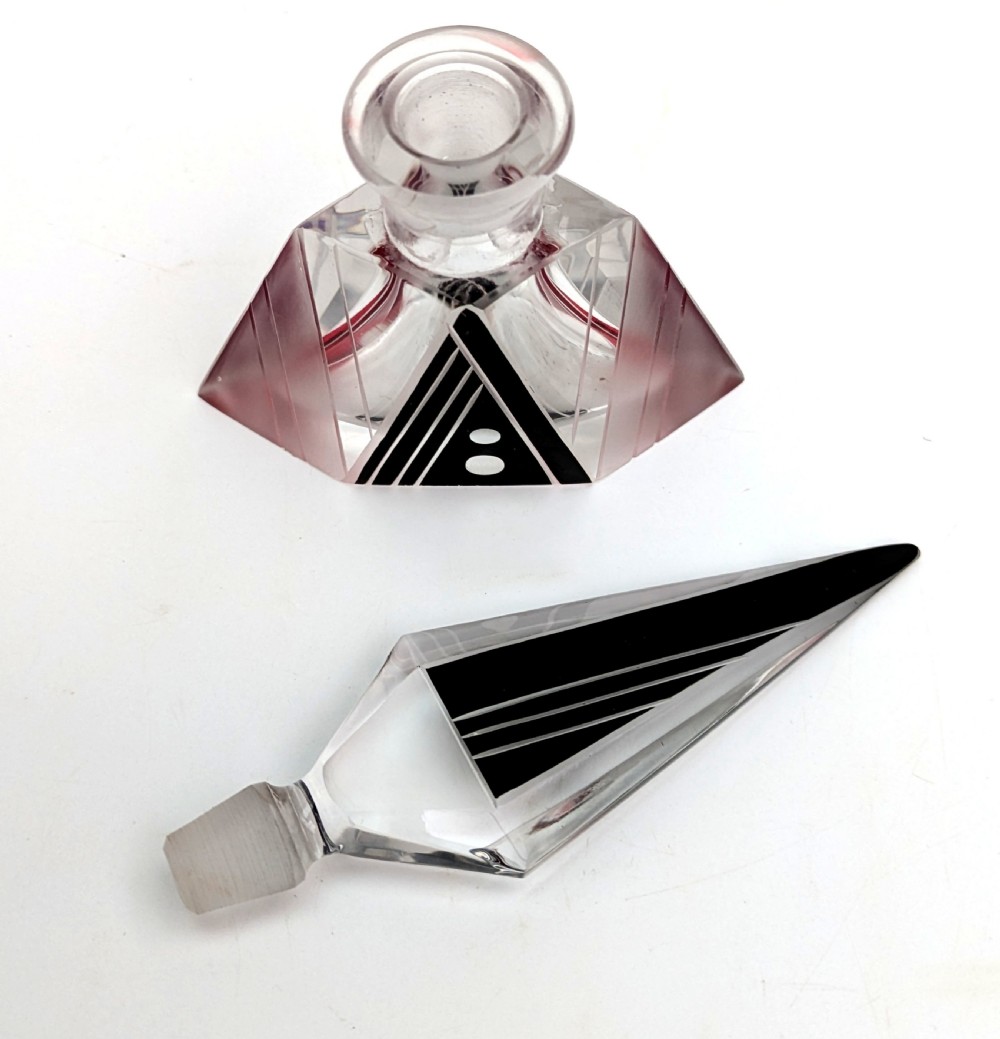 An Art Deco clear and frosted glass perfume bottle featuring a tall faceted stopper and black enamelled geometric designs. View VI