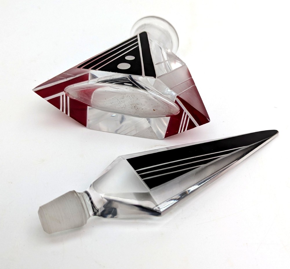An Art Deco clear and frosted glass perfume bottle featuring a tall faceted stopper and black enamelled geometric designs. View VII