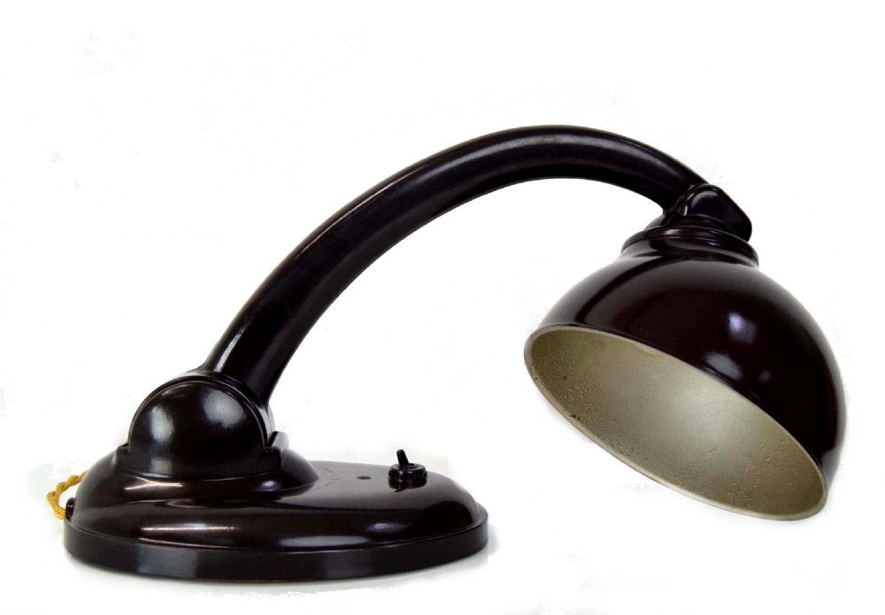 A dark brown Bakelite desk lamp featuring a curved neck, adjustable domed shade with a cream interior, and an oval base with a toggle switch. View VI