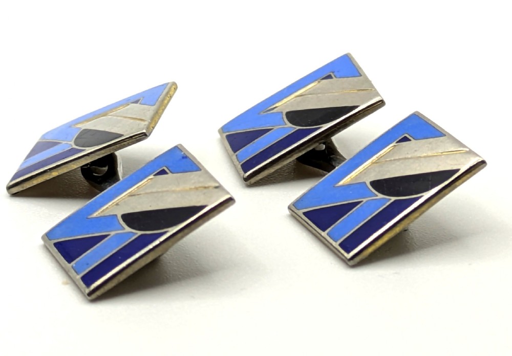 A matching pair of rectangular Art Deco enamel cufflinks featuring geometric patterns in shades of blue, black, and silver-tone metal. View VIII