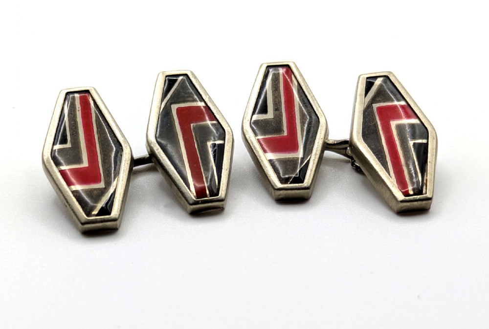 A pair of double-sided Art Deco silver cufflinks with geometric red, grey, and black enamel chevron detailing. View II