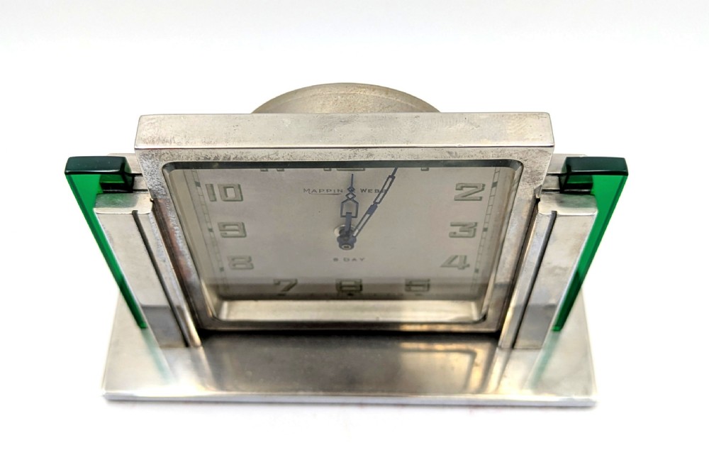 An Art Deco chrome-plated rectangular desk clock featuring green glass side accents and a square dial with geometric numerals. View II