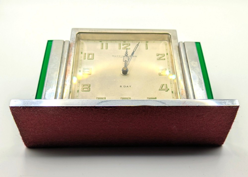 An Art Deco chrome-plated rectangular desk clock featuring green glass side accents and a square dial with geometric numerals. View VIII