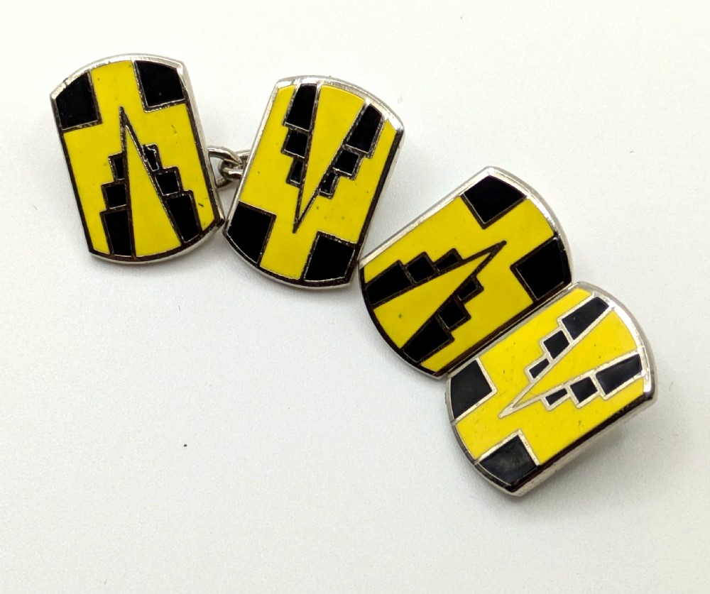 A pair of double-ended Art Deco cufflinks featuring geometric yellow and black enamel designs on silver metal mountings. View II