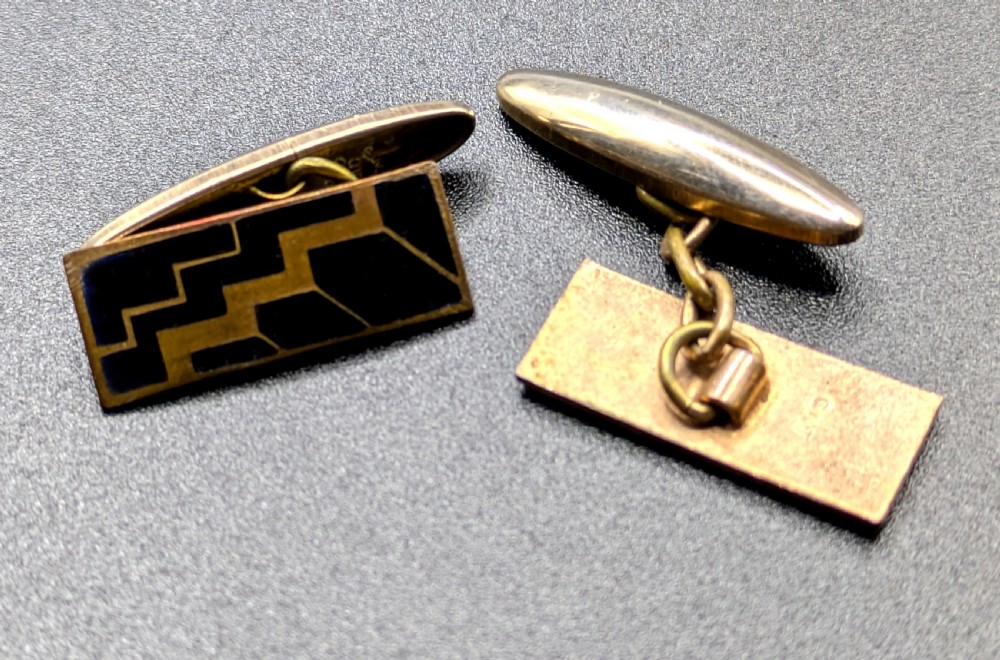 A pair of Art Deco rose gold tone cufflinks with rectangular black enamel geometric panels and torpedo backings. View VI