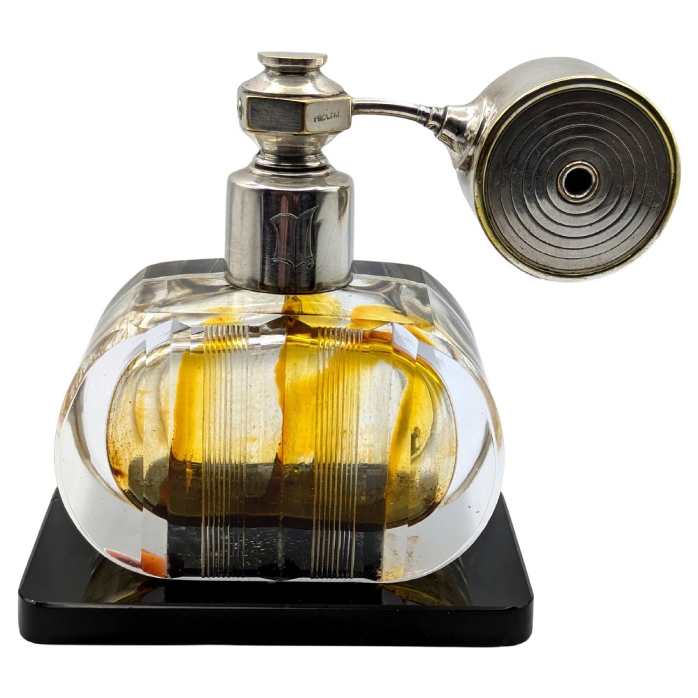 A French Art Deco cut glass perfume atomiser featuring a silver-toned metal spray mechanism mounted on a flat black rectangular base.