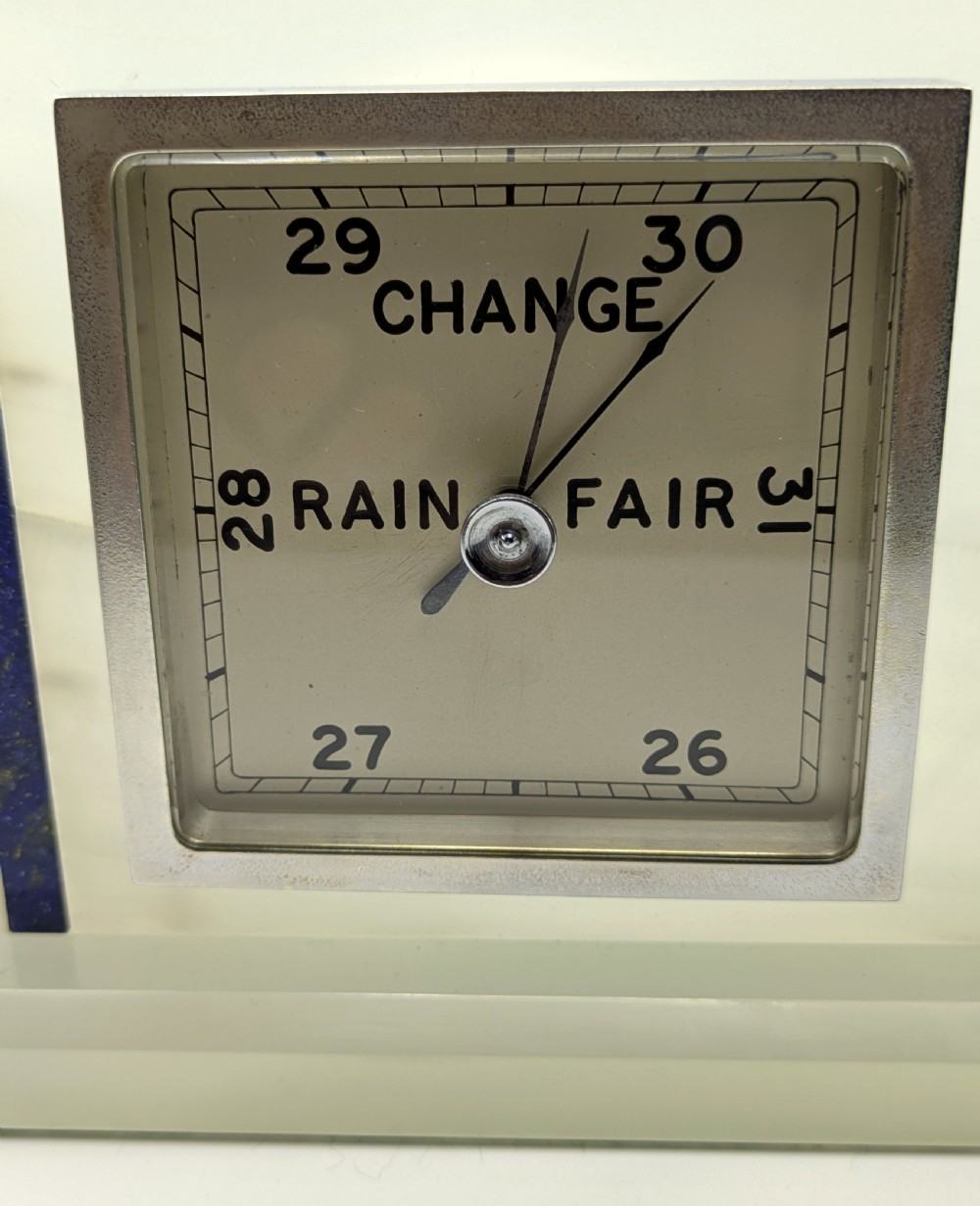 An Art Deco cream onyx desk weather station featuring a square barometer dial, central thermometer, and square clock face flanked by stepped blue lapis lazuli accents. View VIII