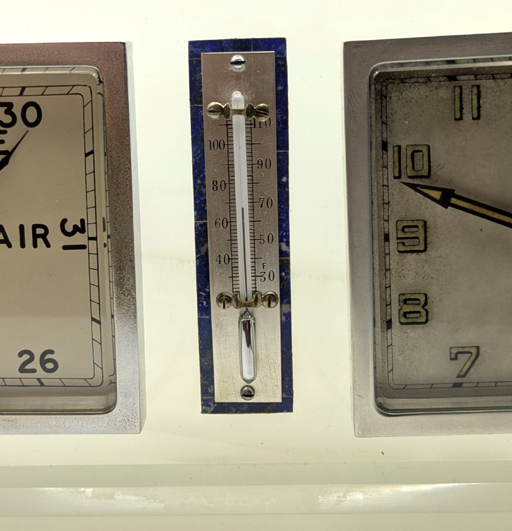An Art Deco cream onyx desk weather station featuring a square barometer dial, central thermometer, and square clock face flanked by stepped blue lapis lazuli accents. View IX
