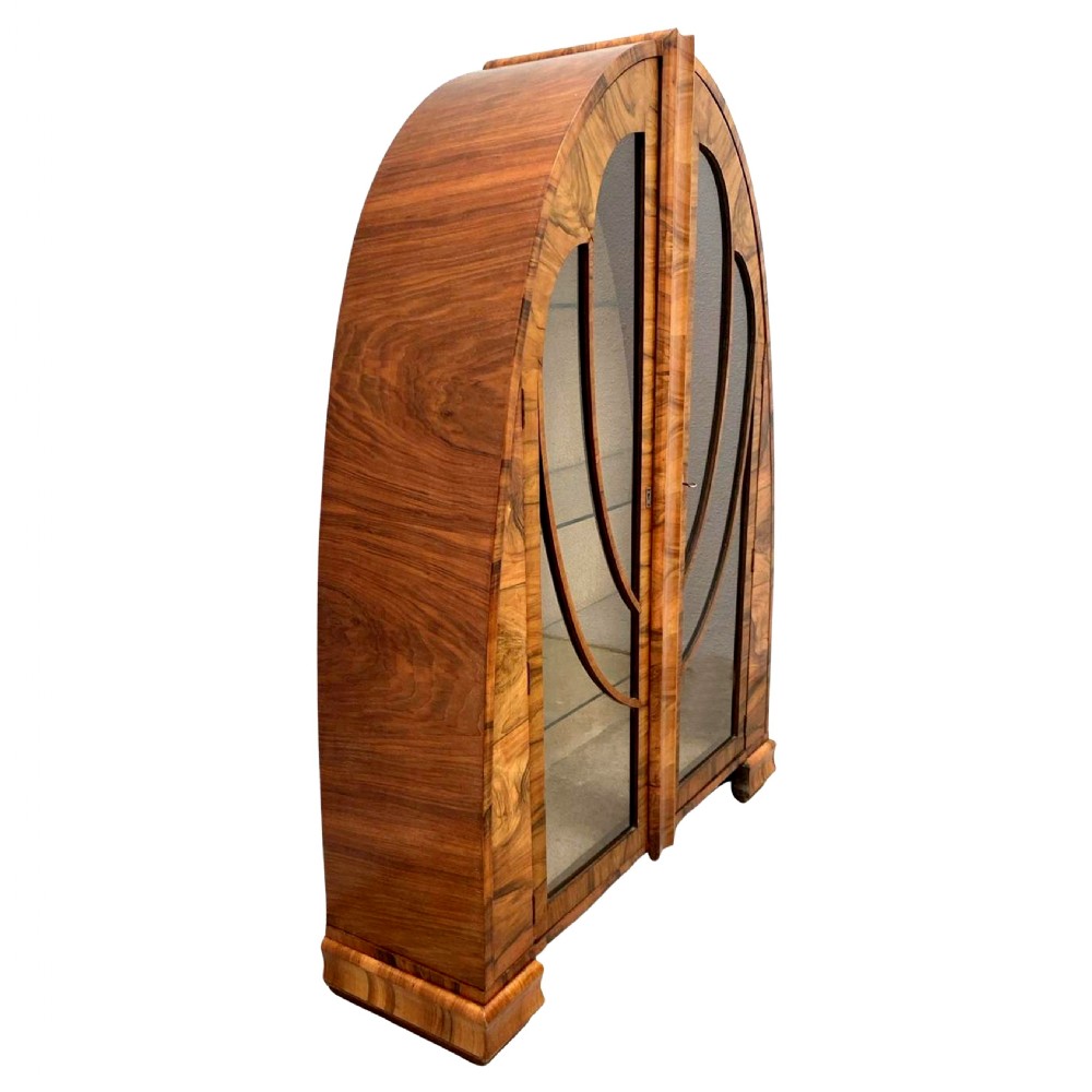 An Art Deco cathedral-arched display cabinet crafted from figured walnut veneer featuring two glazed doors with decorative curved glazing bars. View VI
