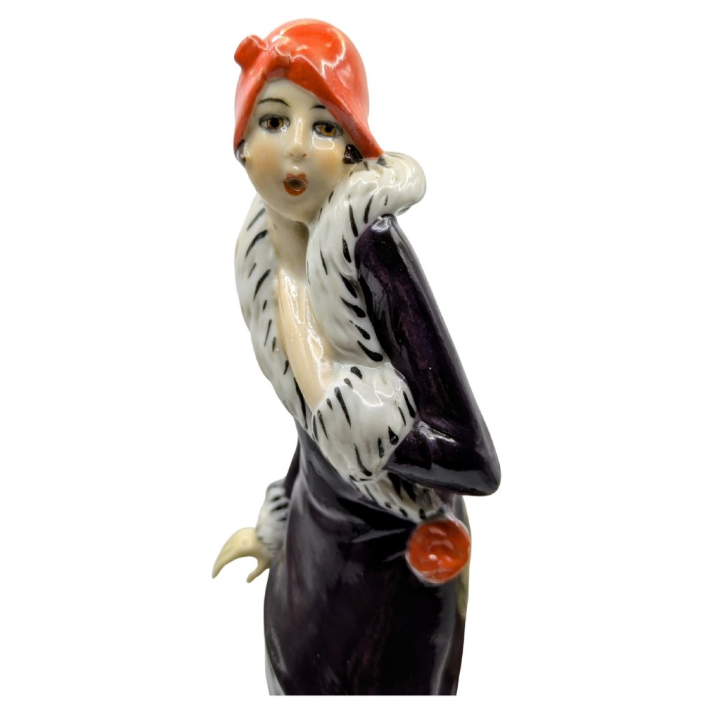 An Art Deco painted porcelain trinket box featuring a flapper lady in a black coat and red cloche hat alongside a small dog. View II