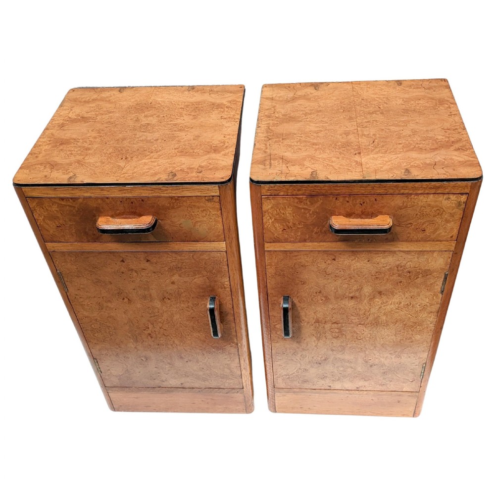 A pair of Art Deco blonde maple bedside cabinets, each featuring a single top drawer and a lower cupboard door with dark wooden handles. View V