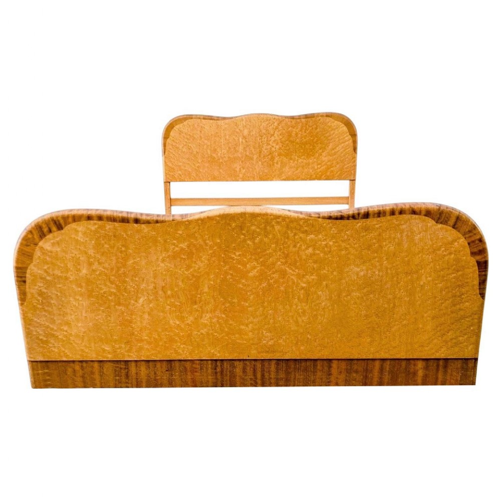 An Art Deco double bed frame featuring a curved headboard and footboard crafted from blonde birds eye maple veneer with darker crossbanded edges.