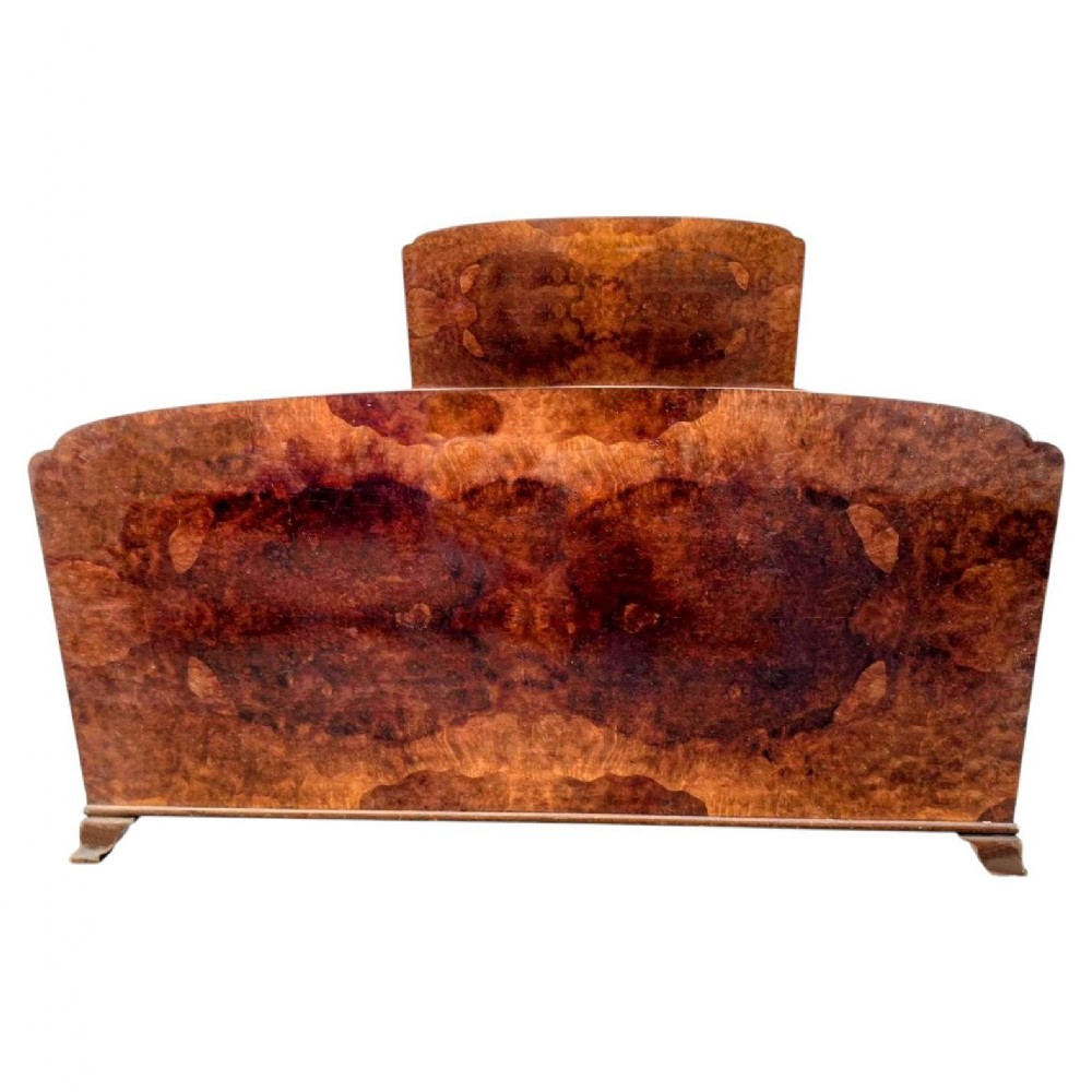 An Art Deco double bed frame featuring a arched burr walnut headboard and footboard with book-matched wood grain.