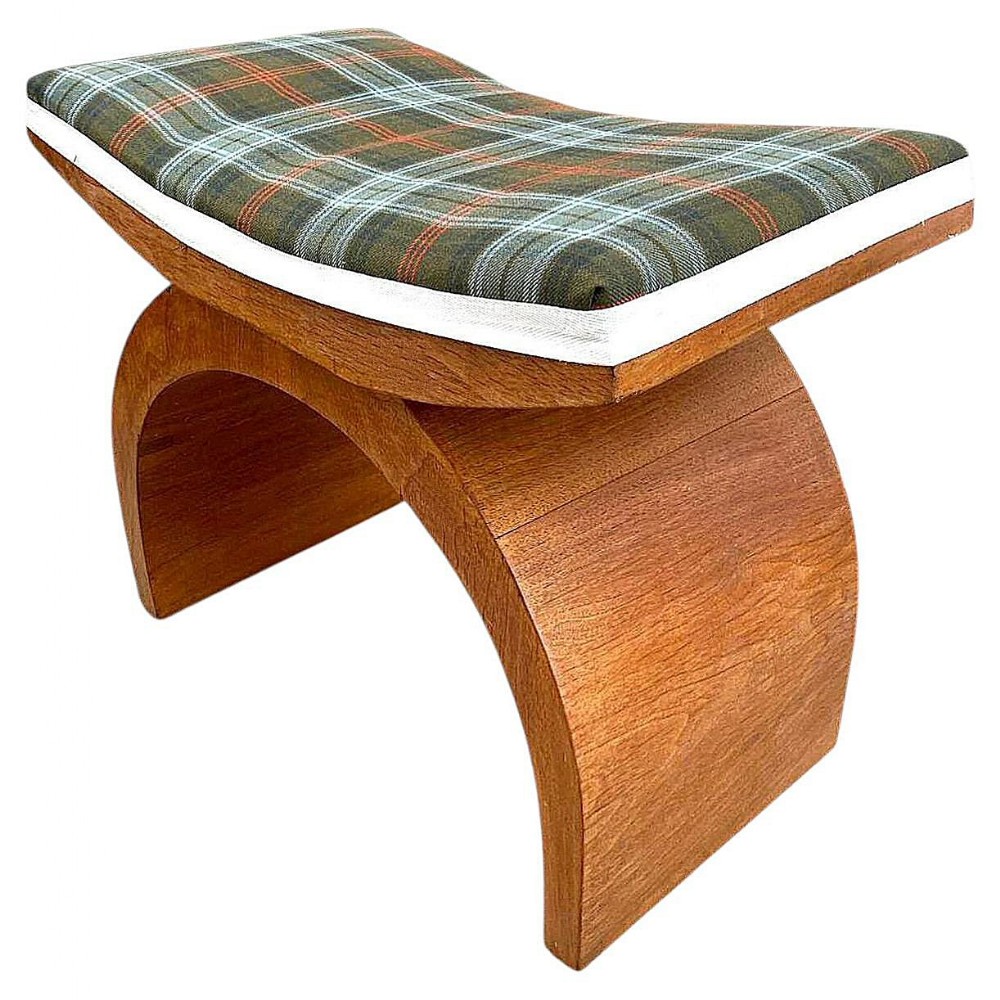 An Art Deco wooden dressing stool featuring sweeping curved legs and a concave padded seat upholstered in green tartan fabric.