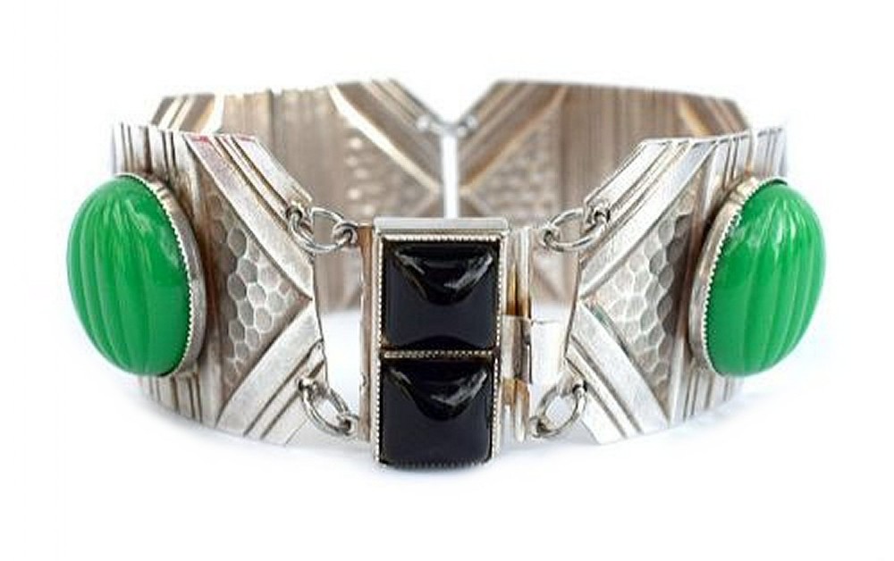 An Art Deco wide chromium cuff bracelet featuring textured geometric panels, central square black glass stones, and round fluted green glass cabochons.