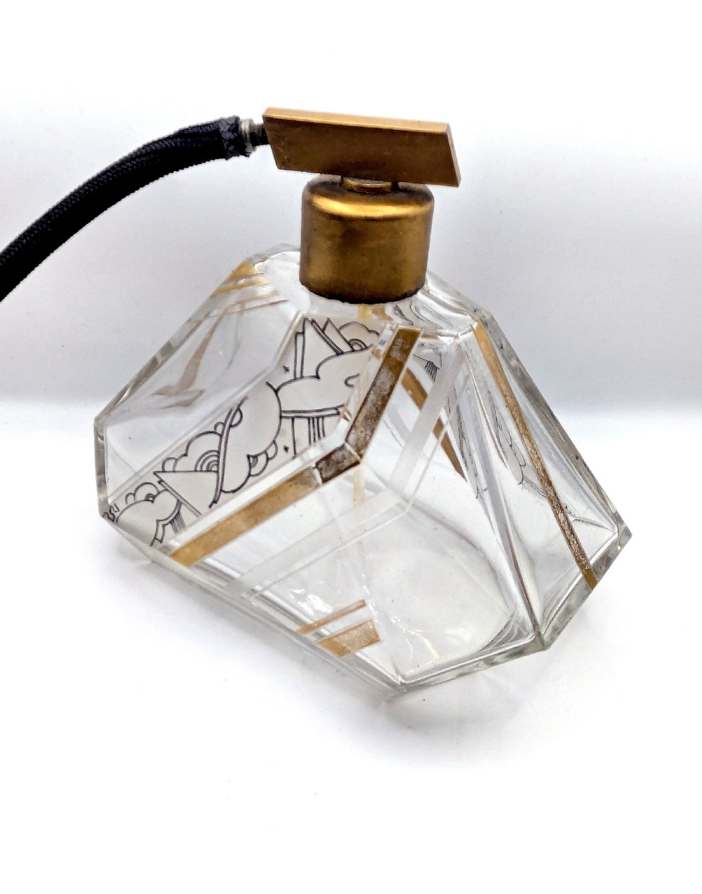 A geometric Art Deco clear glass perfume atomiser bottle with gold and black enamelled patterns, featuring a brass mount and black woven squeeze bulb with tassel. View III