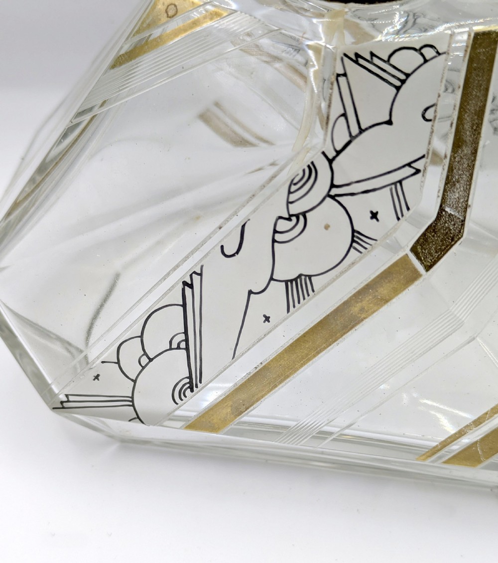 A geometric Art Deco clear glass perfume atomiser bottle with gold and black enamelled patterns, featuring a brass mount and black woven squeeze bulb with tassel. View V