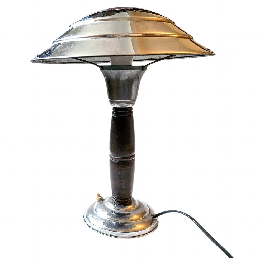 A 1930s Machine Age chrome desk lamp with a tiered metallic shade and a dark turned wood stem on a stepped circular base.