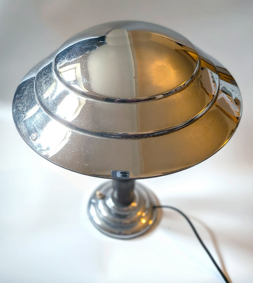 A 1930s Machine Age chrome desk lamp with a tiered metallic shade and a dark turned wood stem on a stepped circular base. View IV