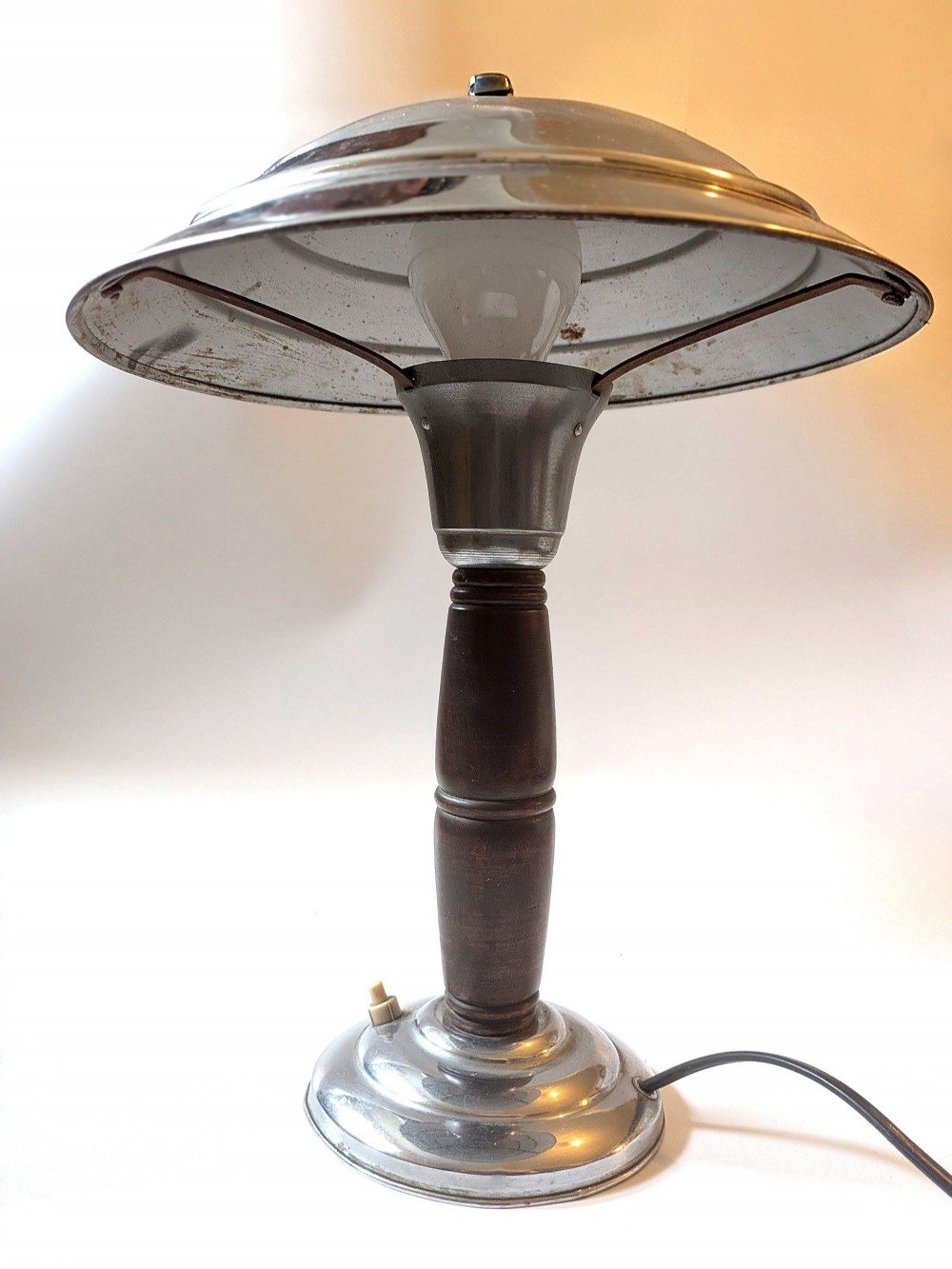 A 1930s Machine Age chrome desk lamp with a tiered metallic shade and a dark turned wood stem on a stepped circular base. View VI