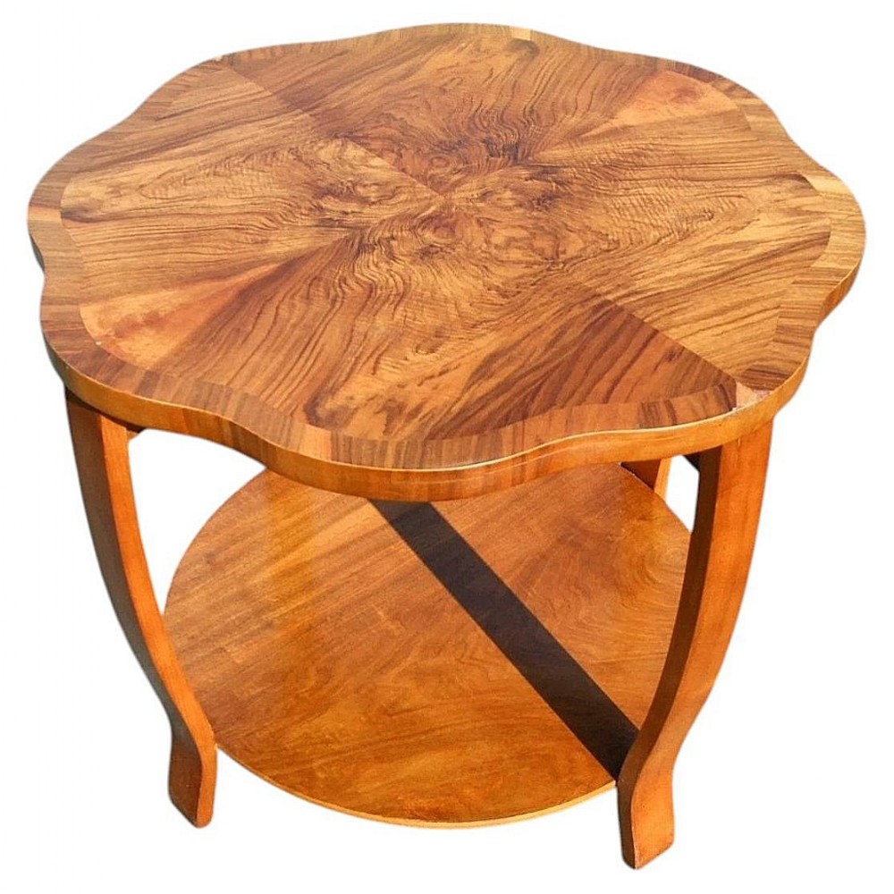 An Art Deco two-tier coffee table made of figured walnut with a scalloped top and curved legs.