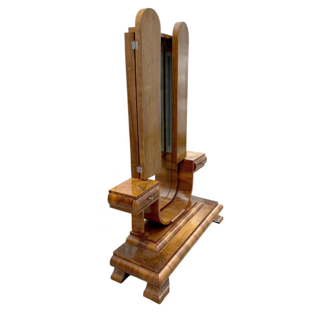 An Art Deco figured walnut freestanding tri-fold cheval dressing mirror with side drawers and stepped plinth base. View II