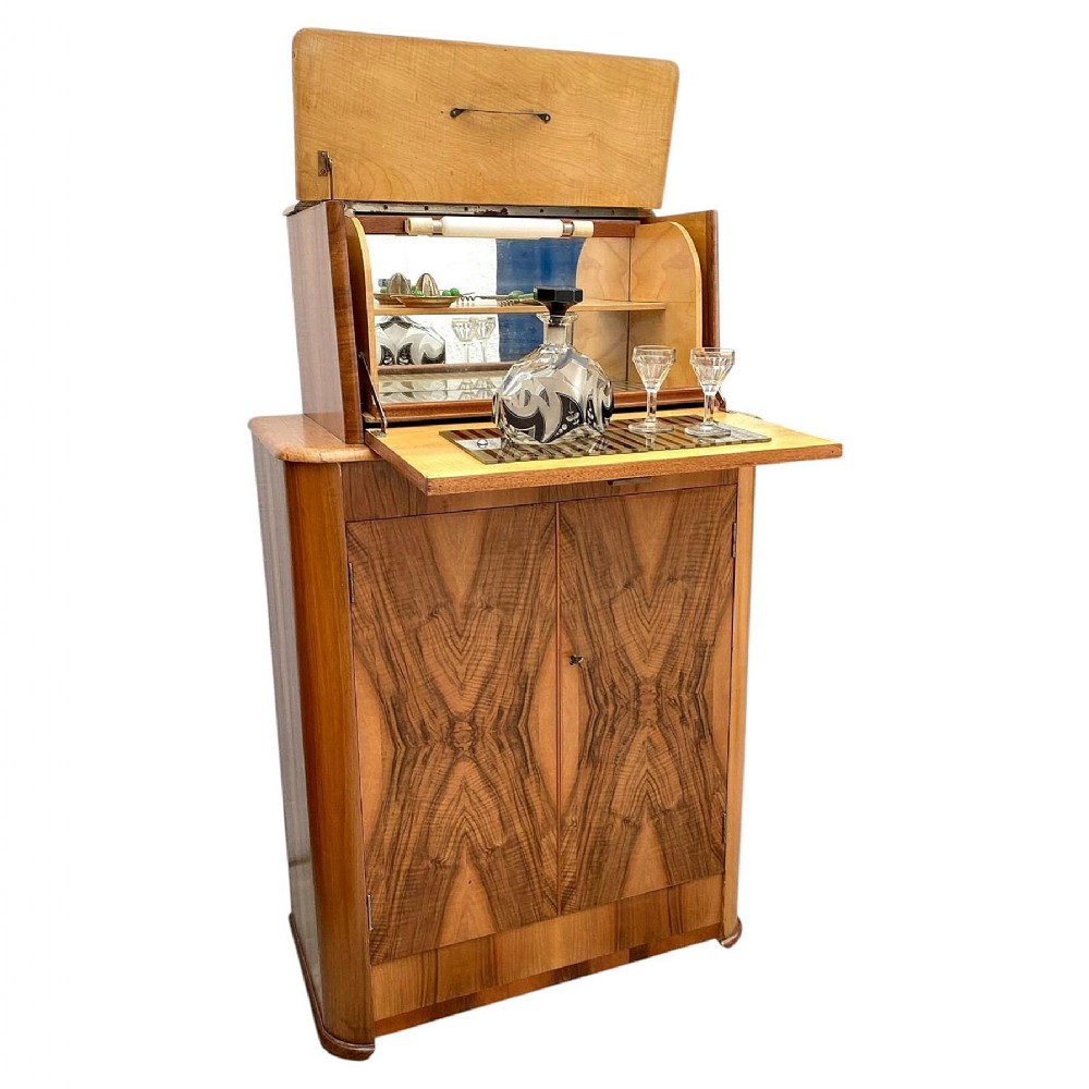 An Art Deco upright walnut cocktail cabinet featuring book-matched veneer doors and an open top compartment with a mirrored interior.