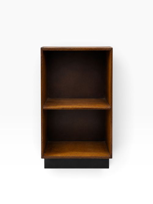 A low 1930s Art Deco ash wood bookcase featuring two open shelves and a contrasting black plinth base. View II