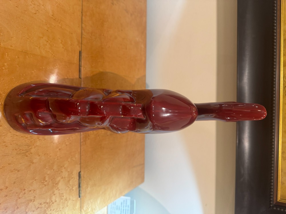 An Art Deco stylised ceramic deer sculpture in a high-gloss maroon glaze featuring gilded accents along the base and eyes. View II
