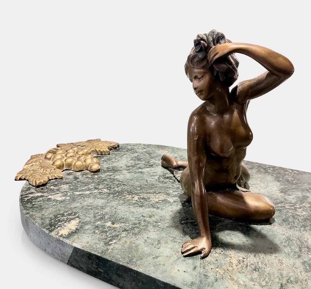 An Art Nouveau bronze figure of a seated woman leaning back on a green marble surface. View VII