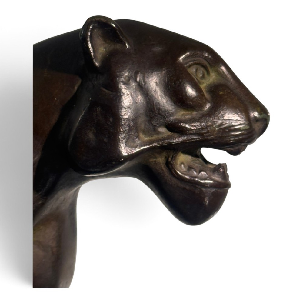 A dark patinated bronze panther sculpture depicted in a low prowling stance with an open jaw, mounted on a rectangular marble base. View II