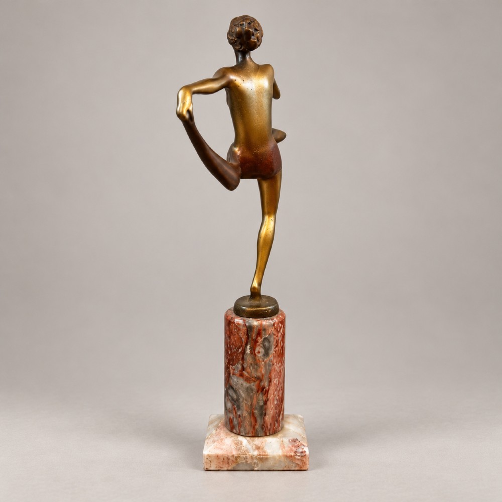 An Art Deco bronzed spelter figurine of a female scarf dancer mounted on a cylindrical variegated marble pedestal. View II