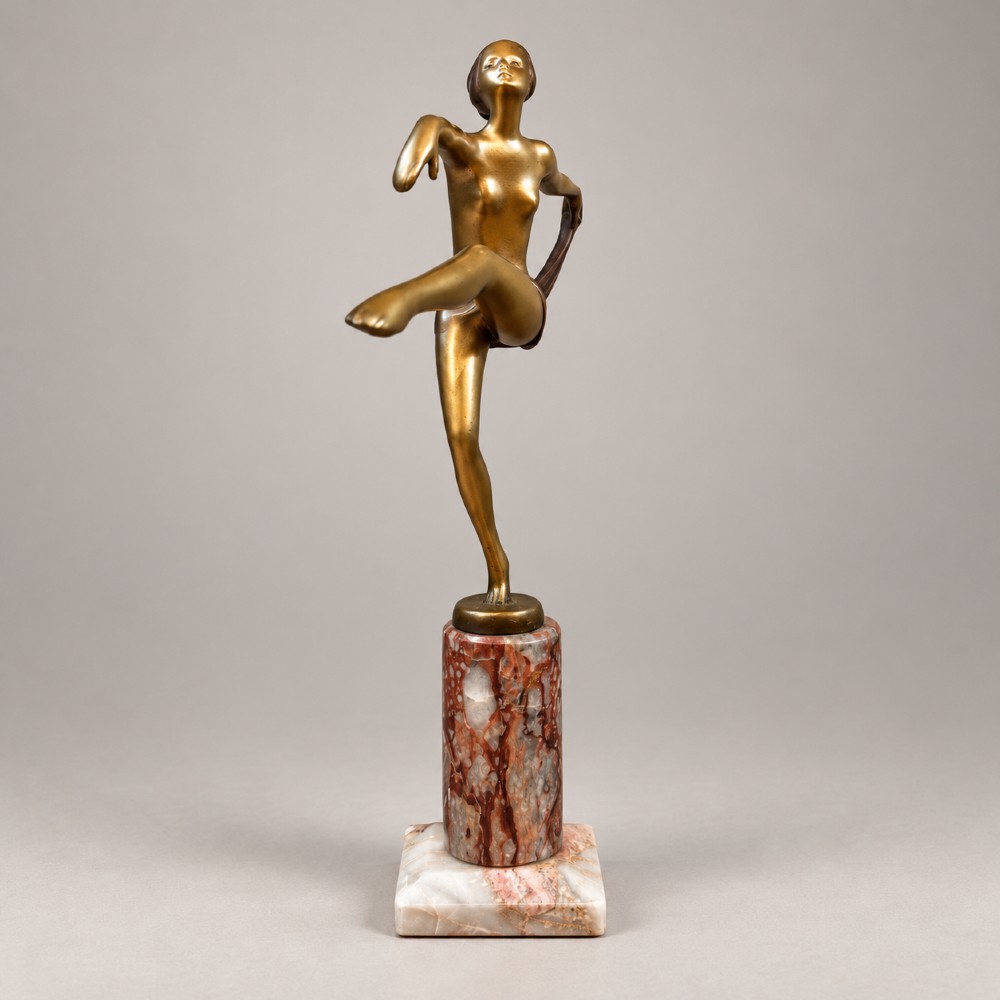 An Art Deco bronzed spelter figurine of a female scarf dancer mounted on a cylindrical variegated marble pedestal. View IV