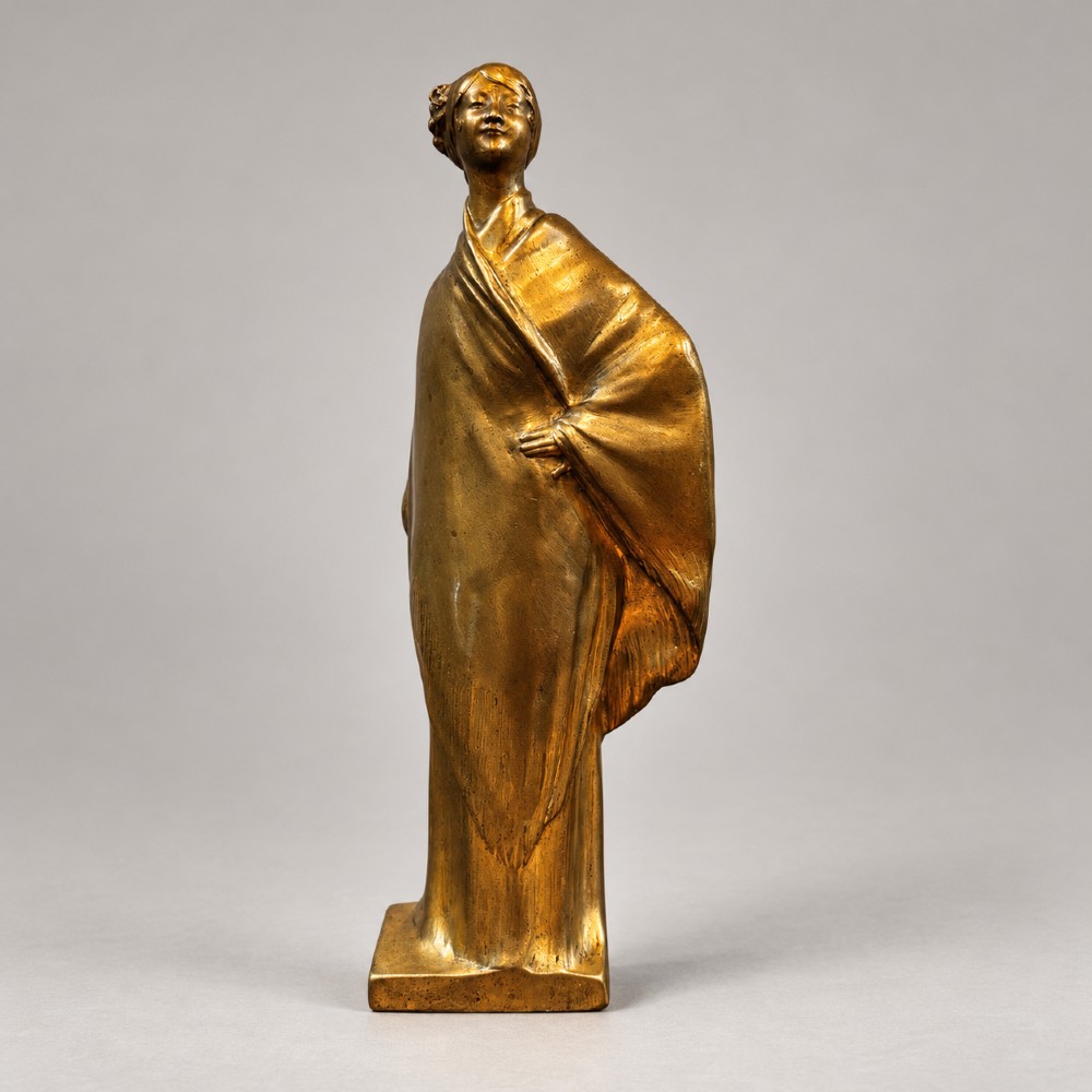An Art Nouveau gilded bronze sculpture depicting a woman draped in a heavy fringed shawl looking upward, mounted on a square integrated base. View II