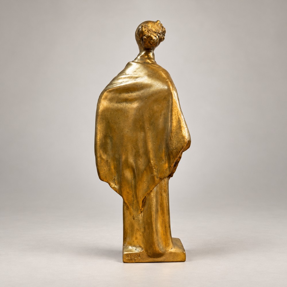 An Art Nouveau gilded bronze sculpture depicting a woman draped in a heavy fringed shawl looking upward, mounted on a square integrated base. View III