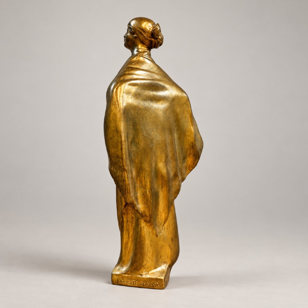 An Art Nouveau gilded bronze sculpture depicting a woman draped in a heavy fringed shawl looking upward, mounted on a square integrated base. View IV