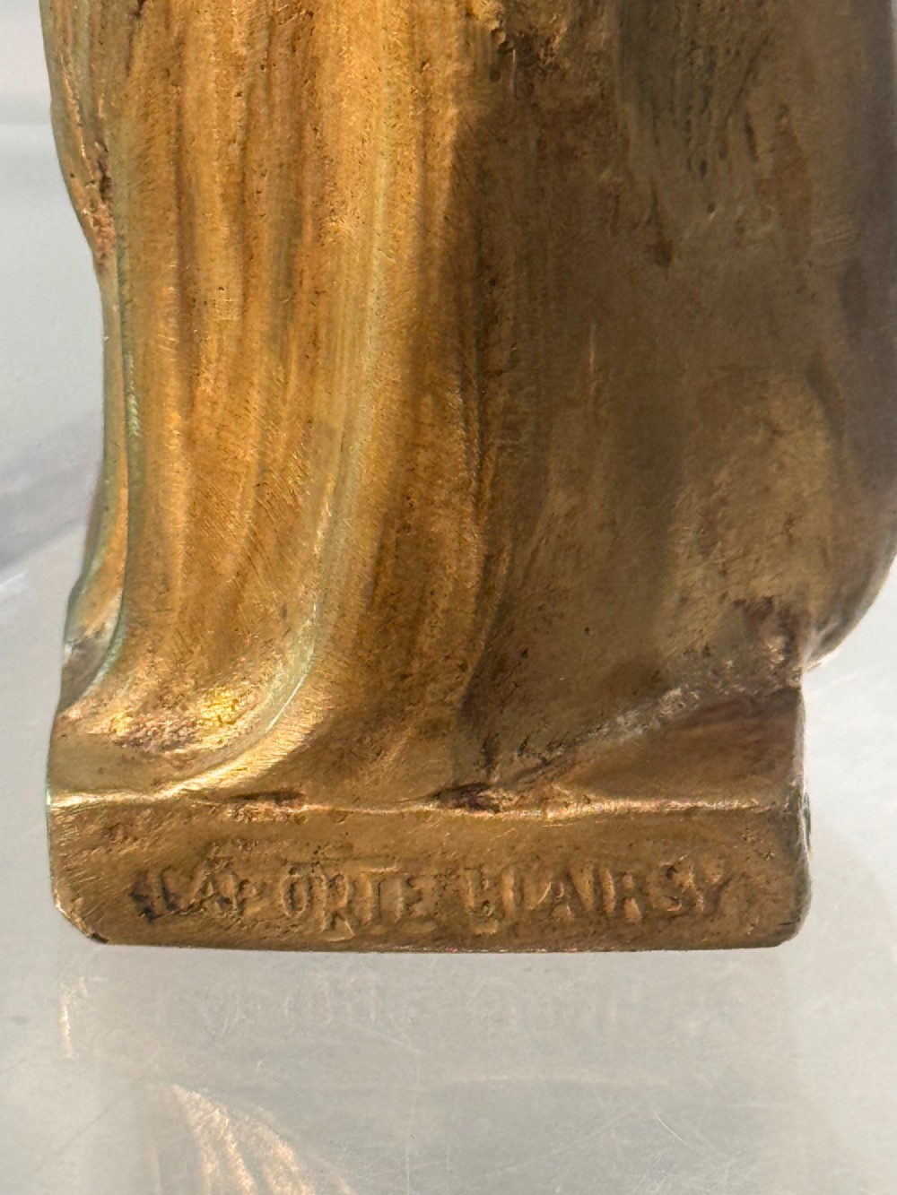 An Art Nouveau gilded bronze sculpture depicting a woman draped in a heavy fringed shawl looking upward, mounted on a square integrated base. View VII