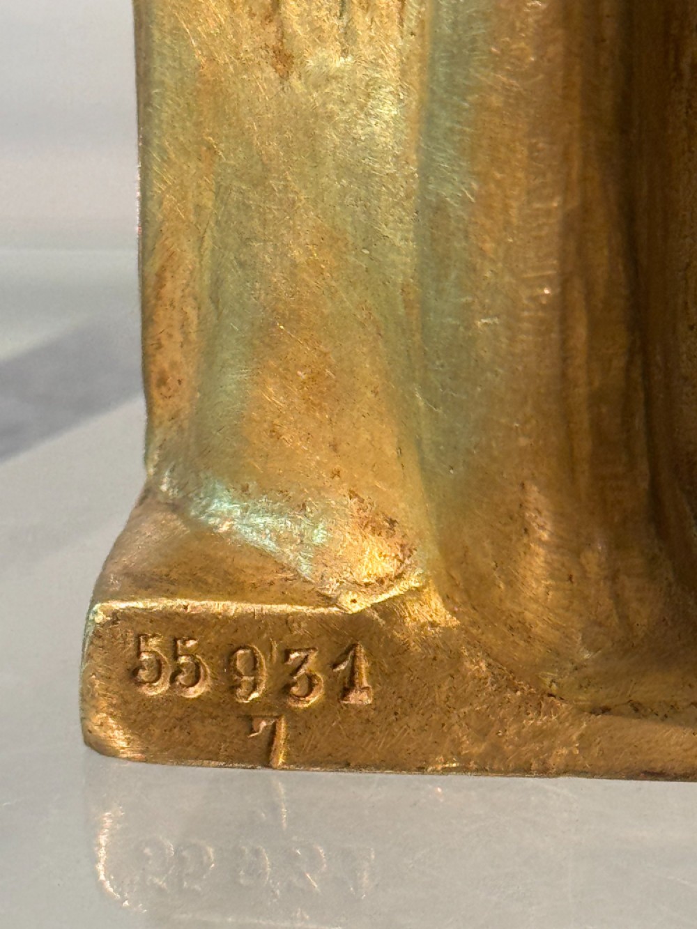 An Art Nouveau gilded bronze sculpture depicting a woman draped in a heavy fringed shawl looking upward, mounted on a square integrated base. View VIII