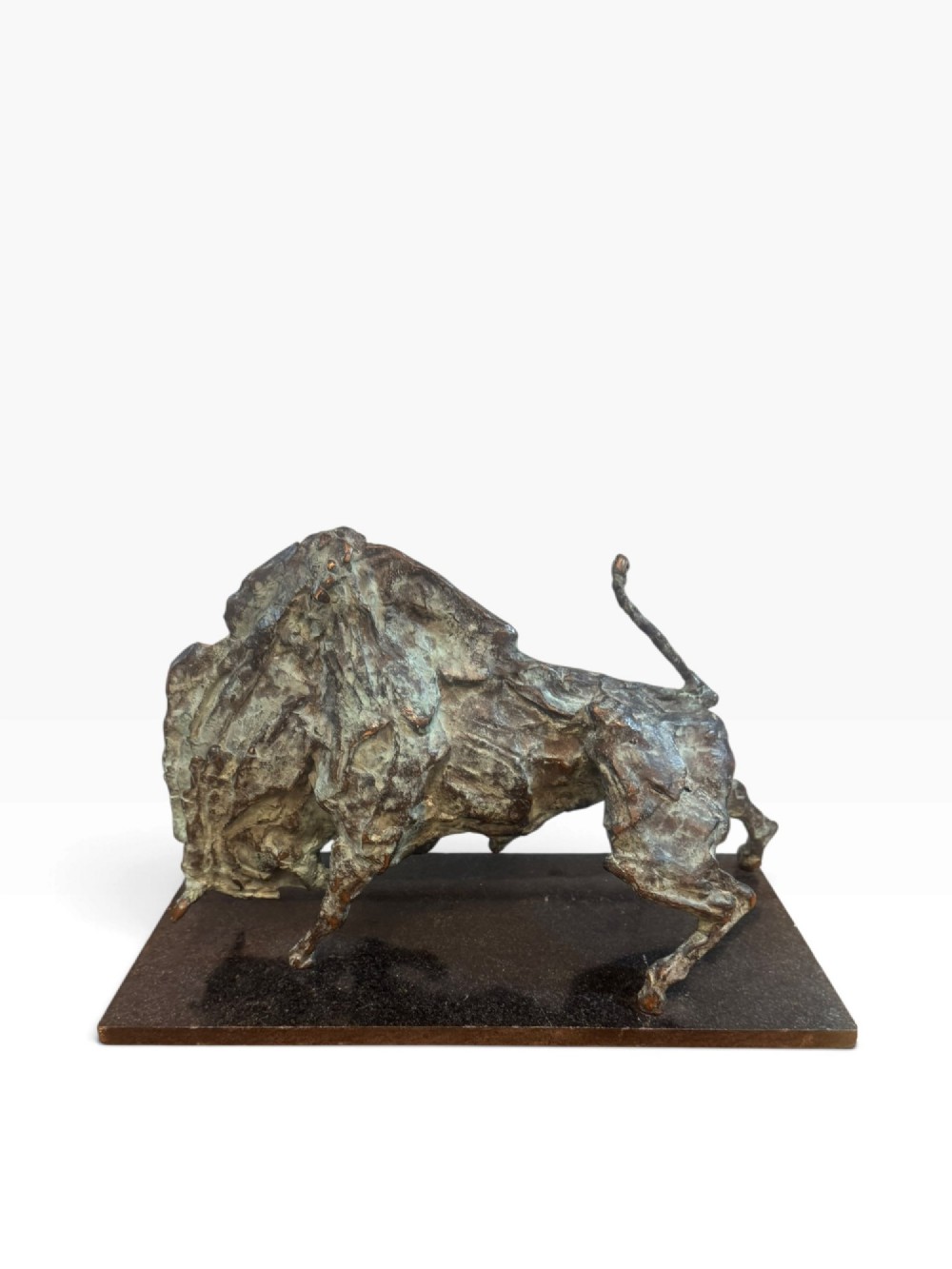 A patinated bronze sculpture depicting a charging bull with a heavily textured surface, mounted on a dark rectangular base.