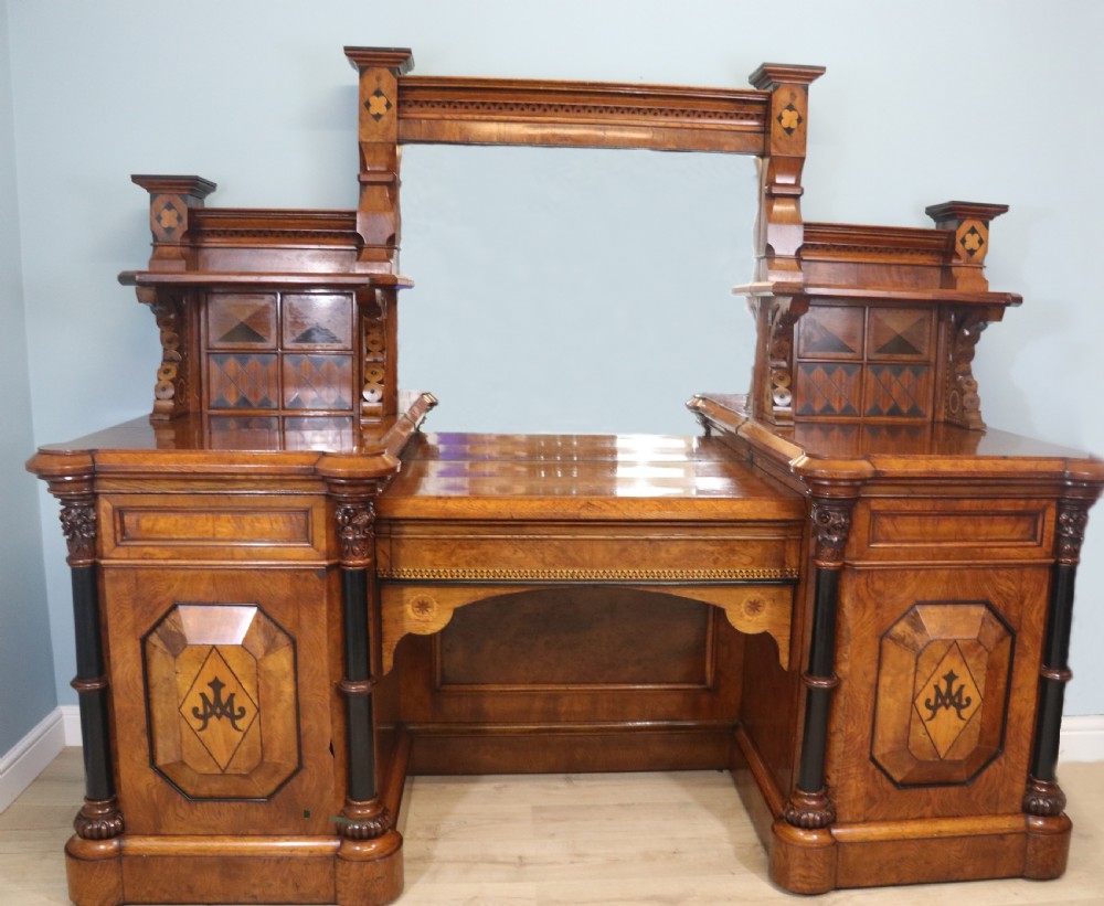 A Victorian Gothic Revival sideboard crafted from pollard oak featuring intricate geometric wood inlays, turned black columns, twin pedestal cupboards, and a tiered upper superstructure.