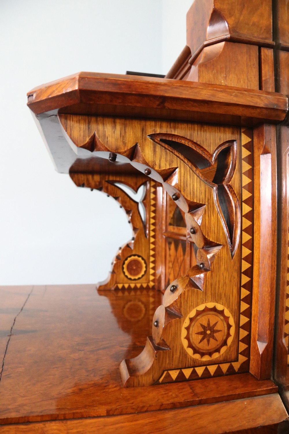 A Victorian Gothic Revival sideboard crafted from pollard oak featuring intricate geometric wood inlays, turned black columns, twin pedestal cupboards, and a tiered upper superstructure. View VII