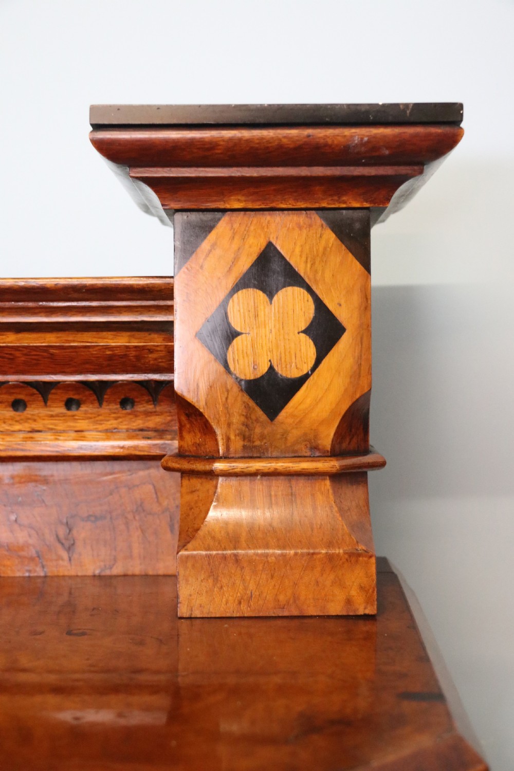 A Victorian Gothic Revival sideboard crafted from pollard oak featuring intricate geometric wood inlays, turned black columns, twin pedestal cupboards, and a tiered upper superstructure. View IX