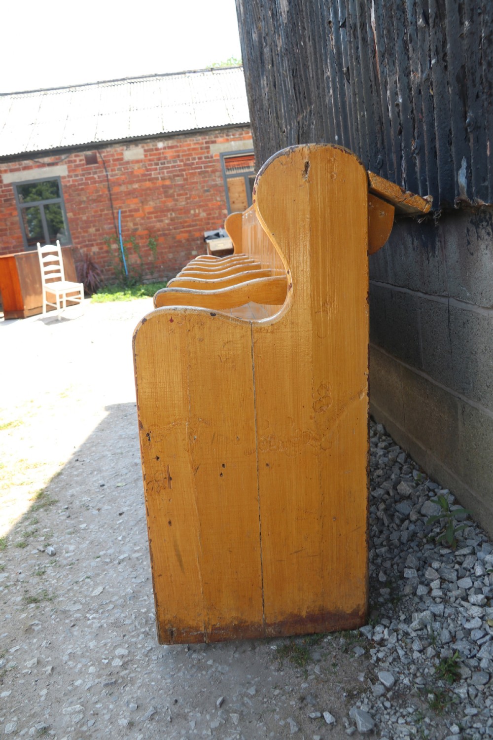 A long Victorian painted pine chapel bench featuring a vertical panelled back, turned arm dividers, and Welsh script along the top rail. View III