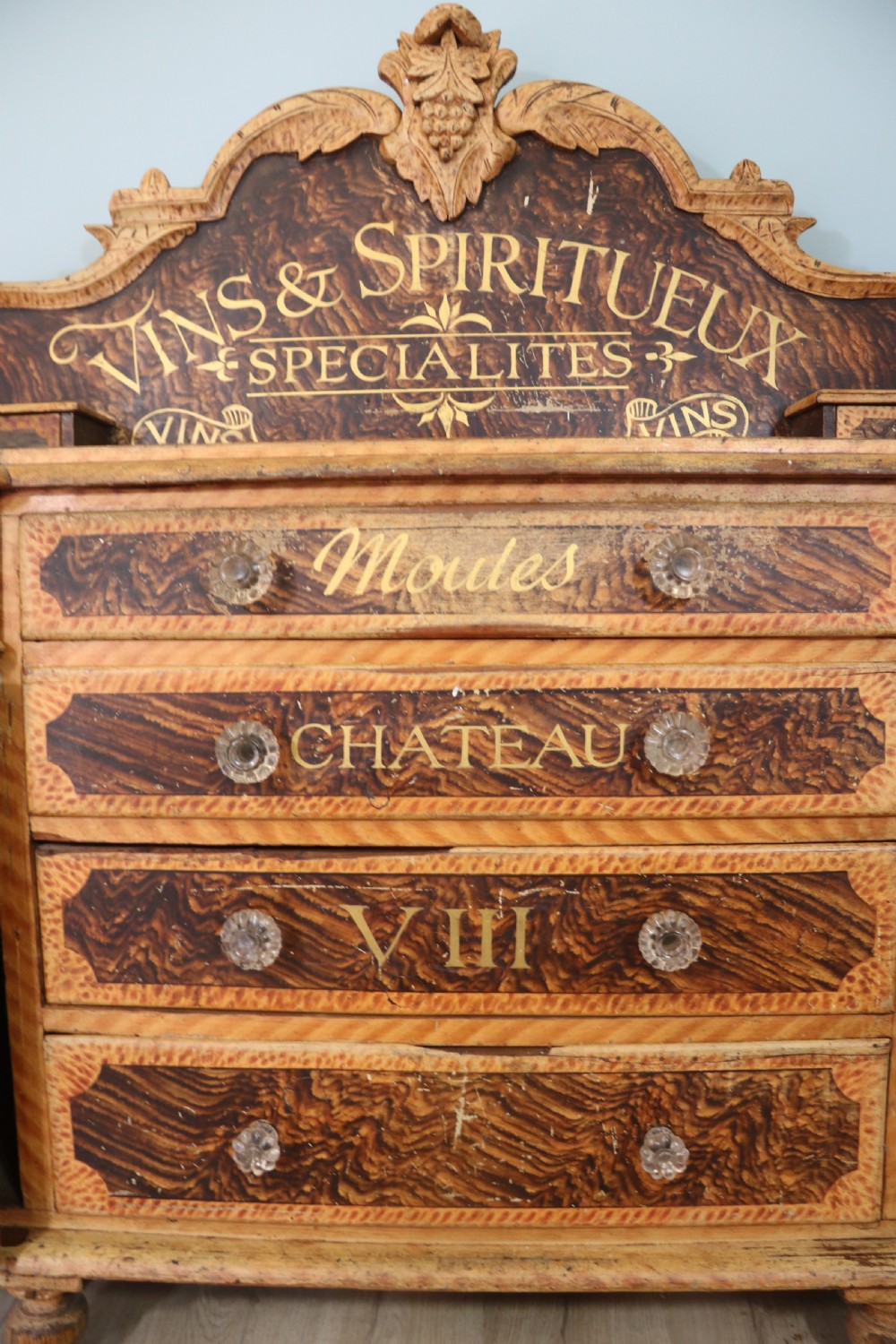 A nineteenth-century French Chateau style walnut sideboard featuring hand-painted French typography, decorative faux-marbling, a carved crest, and glass drawer knobs. View VI