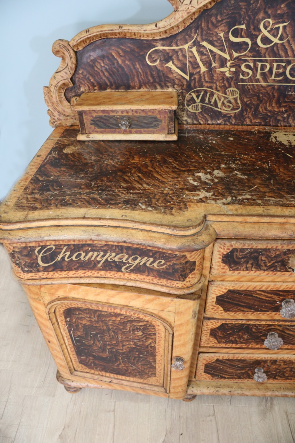 A nineteenth-century French Chateau style walnut sideboard featuring hand-painted French typography, decorative faux-marbling, a carved crest, and glass drawer knobs. View VII