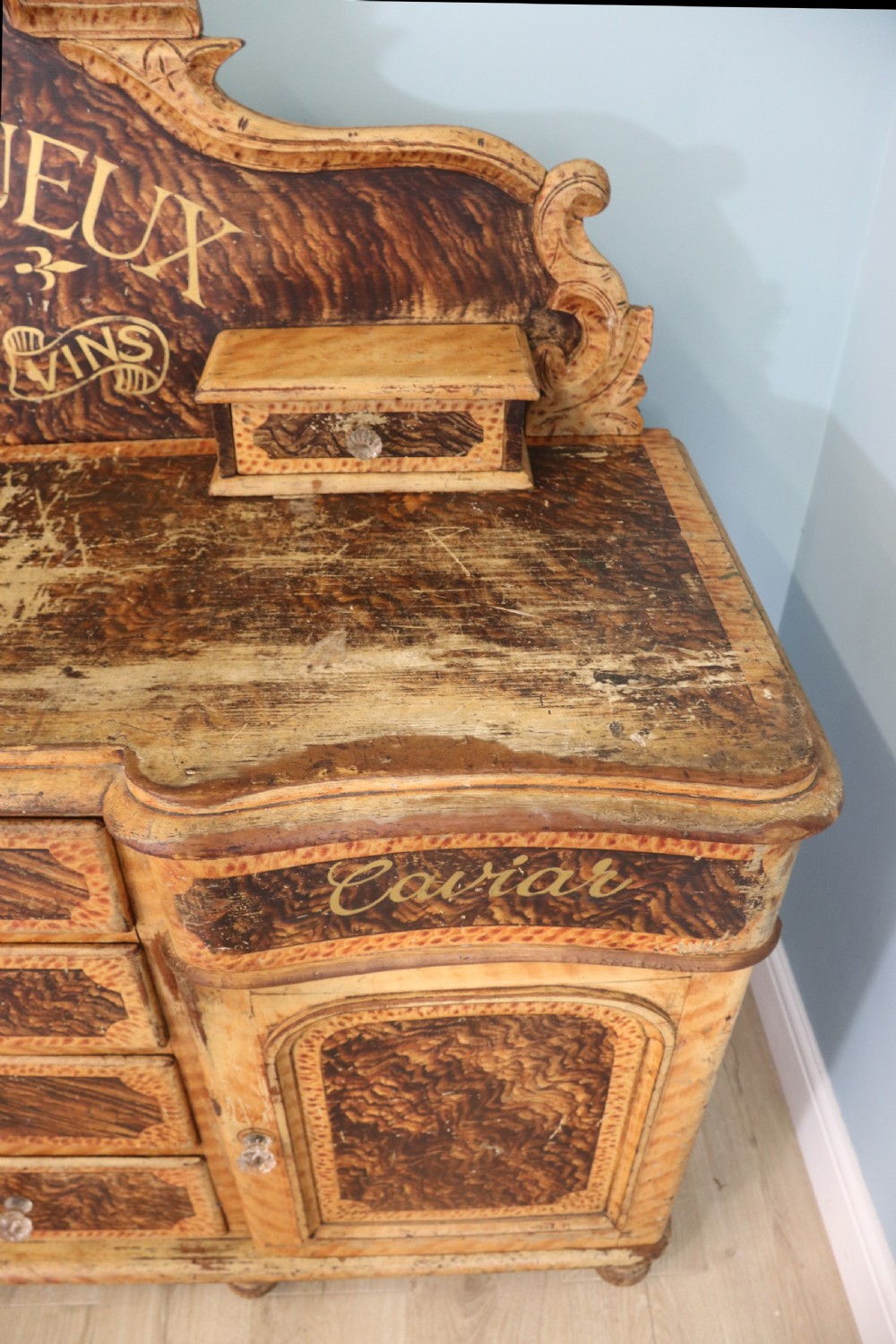A nineteenth-century French Chateau style walnut sideboard featuring hand-painted French typography, decorative faux-marbling, a carved crest, and glass drawer knobs. View IX