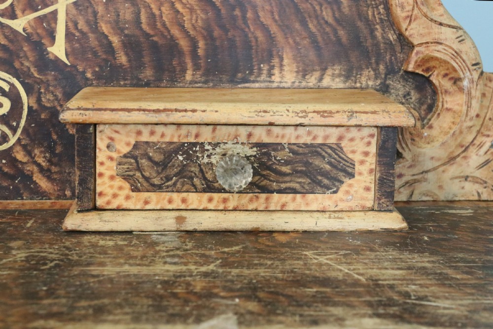 A nineteenth-century French Chateau style walnut sideboard featuring hand-painted French typography, decorative faux-marbling, a carved crest, and glass drawer knobs. View X