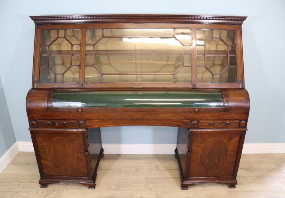 An early nineteenth-century mahogany twin pedestal display cabinet featuring glazed upper doors with geometric glazing bars, a central curved glass display section, and inlaid pedestal cupboards below. View II