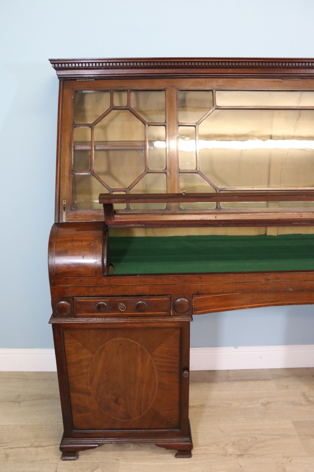 An early nineteenth-century mahogany twin pedestal display cabinet featuring glazed upper doors with geometric glazing bars, a central curved glass display section, and inlaid pedestal cupboards below. View IV